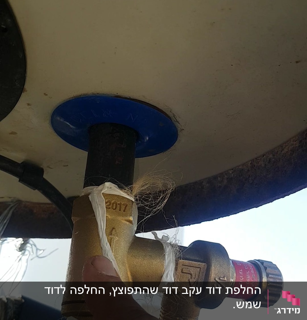 שסתום פליז מחובר לדוד שמש עם אצבע מצביע